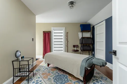 Treatment room with a navy accent wall and a patterned floor rug
